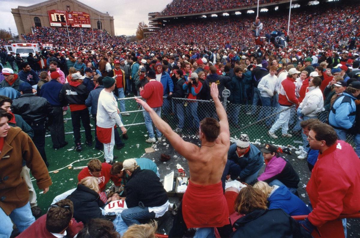 Fans storming the field at Camp Randall Stadium after the Wisconsin Badgers' victory over Michigan on October 30, 1993. The rush led to the infamous 'Camp Randall Crush,' resulting in around 70 injuries and prompting a reevaluation of stadium safety policies. Photo courtesy of The Capital Times.