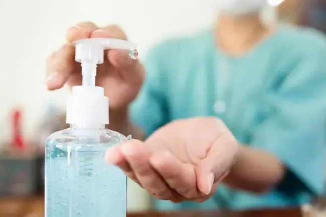 A medical professional sanitizing their hands.